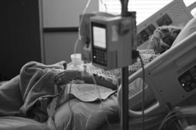 Black and white photo of a patient on the hospital bed