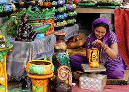 Indian woman painting colorful pottery