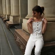 brunette in white posing near the columns