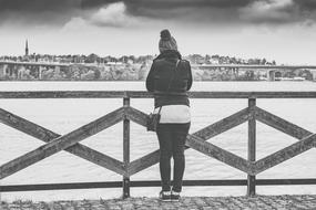 back View of Woman at fence in front of city, sweden, Stockholm