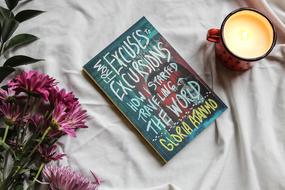 flowers, book and mug on cloth, still life