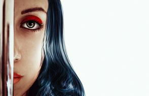 Portrait with the half face of the girl with colorful make-up, near the shiny construction