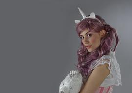 Portrait of the unicorn girl with purple hair and make-up, and accessories