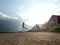 distant Young girl jumping at sky