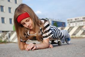 pretty child Girl laying on Skateboard