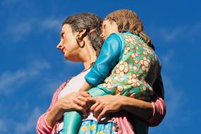 sculpture of mother and daughter on her arms