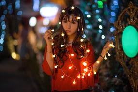 Asian woman with bulb garland