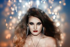 Portrait of the beautiful woman, with the make-up and earrings, at background with the colorful bokeh lights