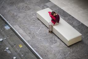 girl with a pillow on a white bench