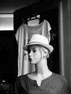 Black and white photo of the mannequin, in the hat, near the t-shirt