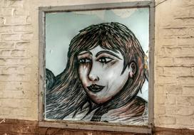 woman as a graffiti on a brick wall