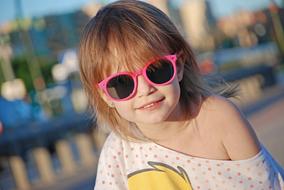 little girl in sunglasses on a blurred background
