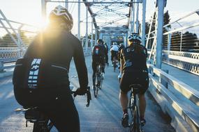 People bikers on bridge at sunset