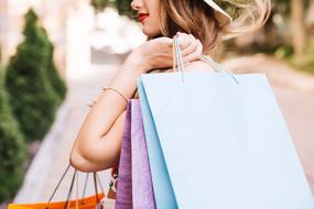 beautiful woman with shopping bags on blurred background