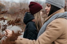 mother with daughter outside in autumn