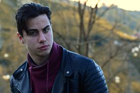 young man in leather jacket on blurred background
