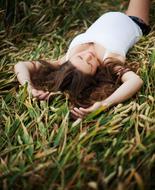 Pregnant woman is lying on the grass