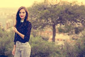 Model near the trees and landscape with the city