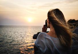 girl photographs the evening sea