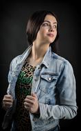 portrait of a girl in a denim jacket on black background