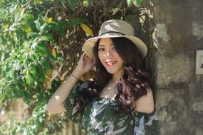 Smiling woman in hat, near the green plants in Dalat, Vietnam