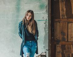 girl in jeans posing near the old building