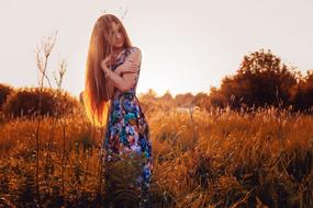 girl with long hair posing on a hayfield
