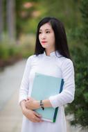 Asian woman in white in the park on a blurred background