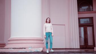 photo of a girl against the background of a pink facade of a building in Moscow