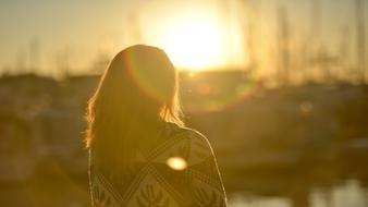 photo of a girl on a background of bright sunrise