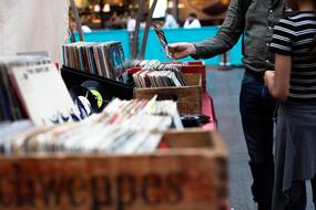 people at market stall with music records