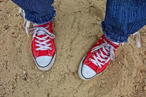 womanâs foot in red sneakers