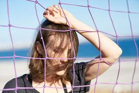 Portrait of the girl, in front of the purple net