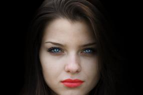 Portrait of the beautiful woman with colorful make-up, at black background