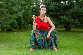 photo of a girl in a mexican dress in a green park
