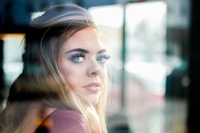 girl with long eyelashes behind glass