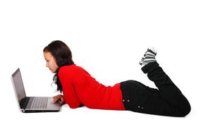 girl in a red sweater looking at the laptop screen