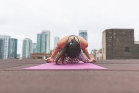 woman exercising yoga on roof