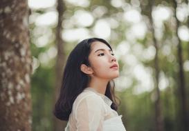 portrait of a young girl near a tree on a blurred background
