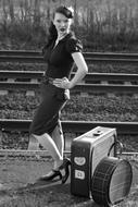 black and white, retro girl with luggage on the platform