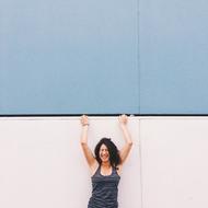 a girl in a blue t-shirt stands near the wall