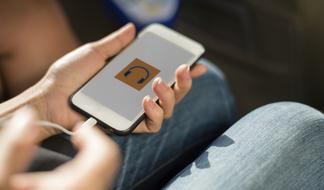 Woman in jeans, using headphones on the white phone