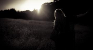 silhouette of a girl on a meadow in the bright sun