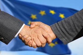 Friendship, handshaking at flag of European union