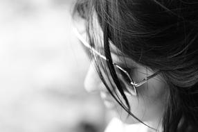 black and white photo of a girl in sunglasses with a blurred background