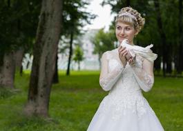 bride posing with a dove in the park