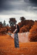 Woman in patterned dress, among the colorful and beautiful plants in autumn