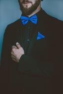 man in black suit with blue tie