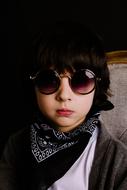 portrait of a boy in sunglasses and a scarf