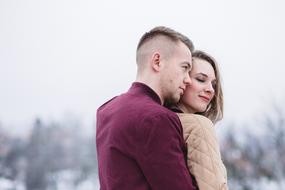 a guy with a girl hugging in the fresh air